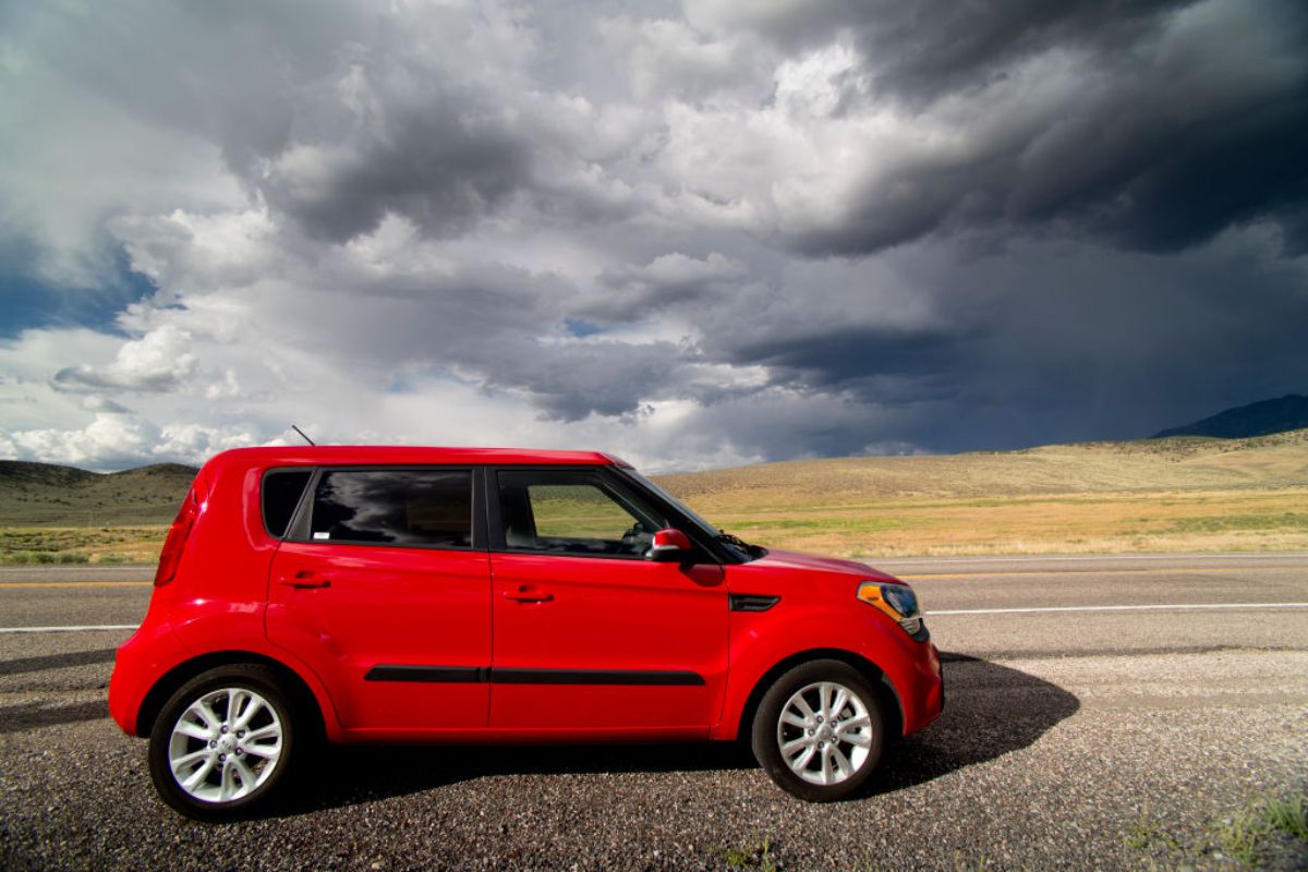 A red 2014 Kia Soul parked on the side of the road.