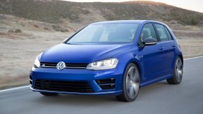 A 2015 Volkswagen Golf R, a cheap fast used car, blasts down a back road while it shows off its blue paintwork.