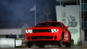 A Dodge Challenger SRT Demon does a wheelie at a drag strip.