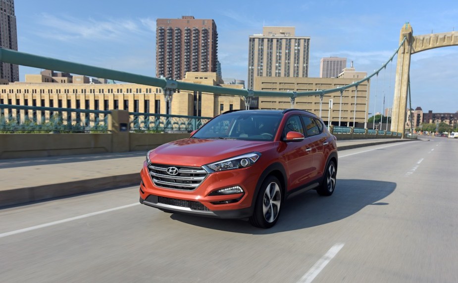 A red 2018 Hyundai Tucson driving down a highway.