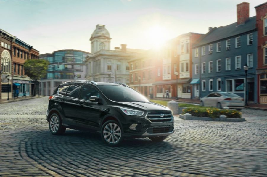 A black 2019 Ford Escape driving on a city street.