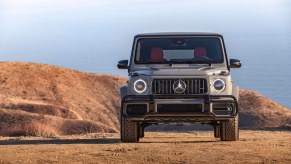 This is a promo photo of a 2021 G Class SUV parked on a sand dune in front of the ocean.