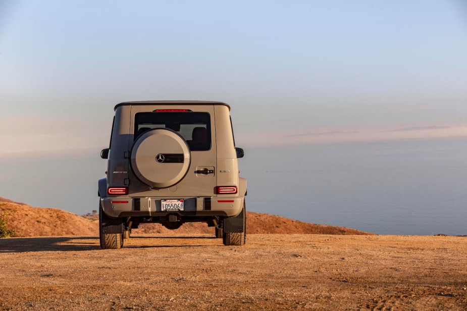 The back of an AMG G 63 G Class SUV from 2021 parked off-road with blue sky visible in the background.