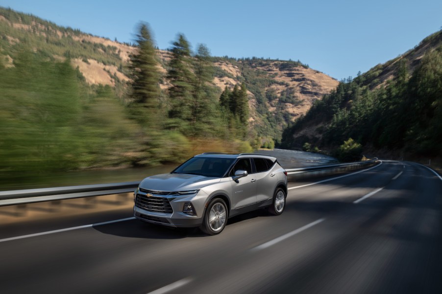 A 2022 Chevy Blazer, where Blazer Insurance costs may be needed as it drives down the road in a wooded area.