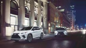 2022 Lexus RX 450h luxury hybrid SUV models on a city street lit with night lights and traffic