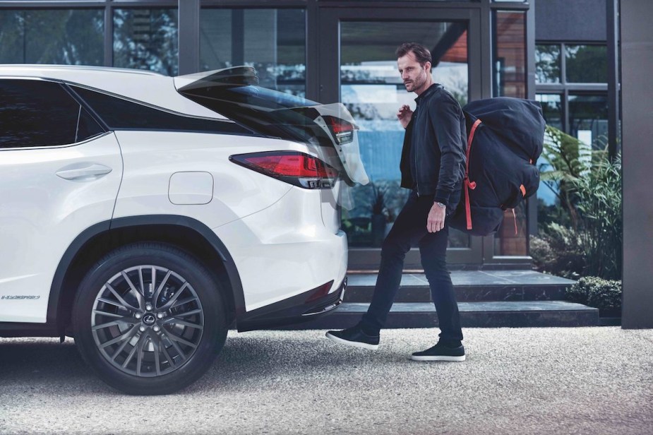 A white 2022 Lexus RX350 with someone walking to it, which is one of the best luxury hybrid third-row SUVs.