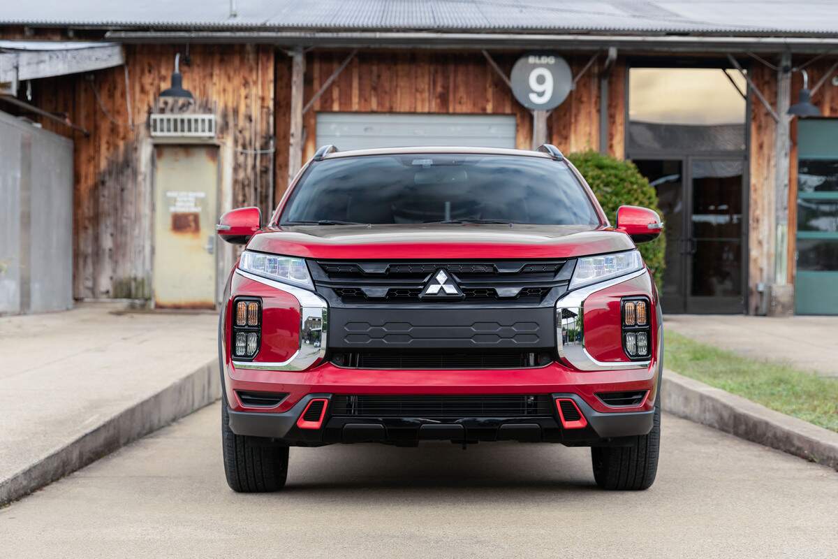 A red 2022 Mitsubishi Outlander Sport sitting in a drive way.