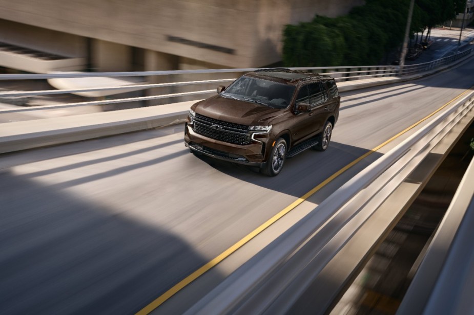 A brown 2023 Chevy Tahoe LT full-size SUV driving on a highway, what are the standard features?