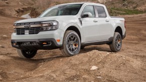 A white 2023 Ford Maverick driving in the dirt.