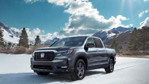 A blue Honda Ridgeline parked in a snowy environment.