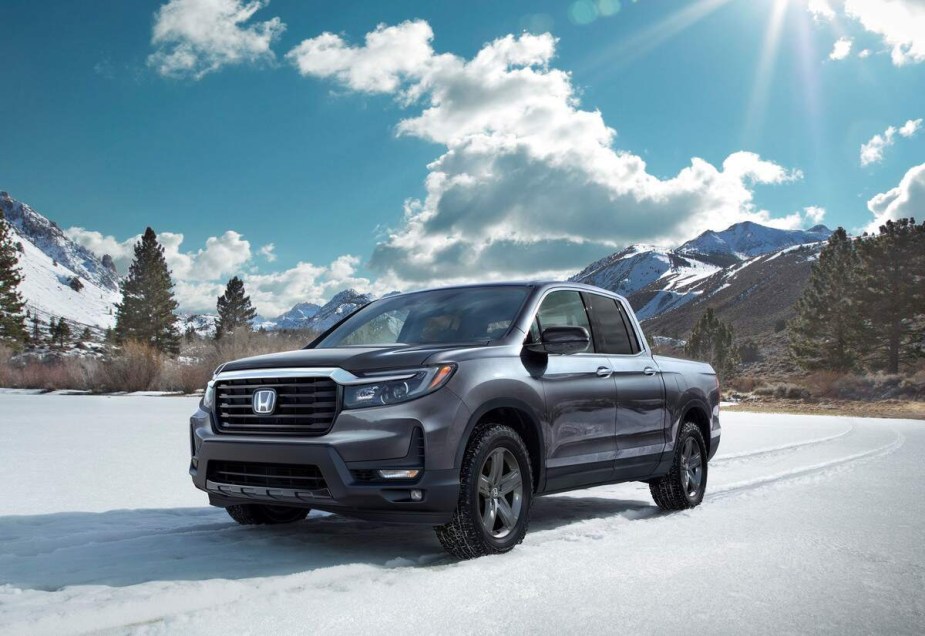 A blue Honda Ridgeline parked in a snowy environment. 