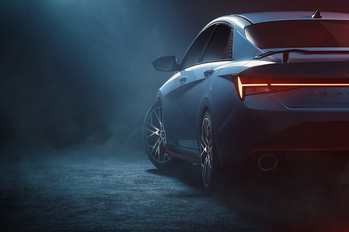 2023 Hyundai Elantra N viewed from the left rear in a darkened hazy room