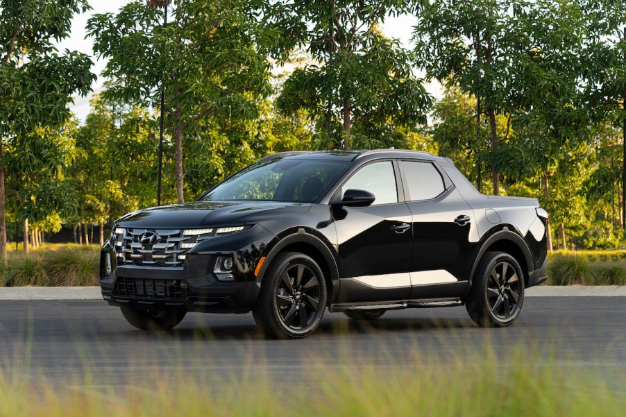 A black 2023 Hyundai Santa Cruz truck parked in a green area.