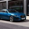 A 20223 Jaguar XF driving down a street.