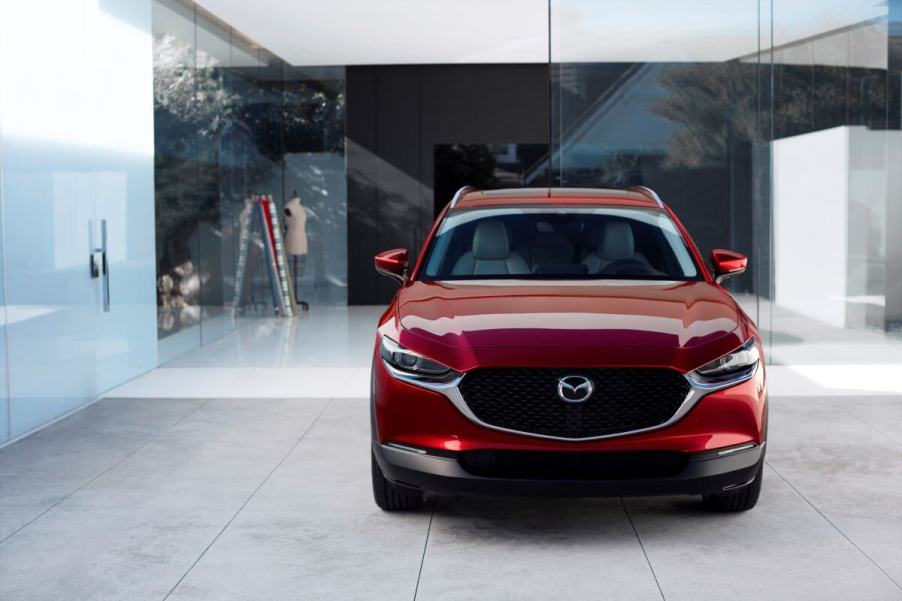 A red 2023 Mazda CX-30 subcompact crossover SUV model in a room paneled with see-through glass plating