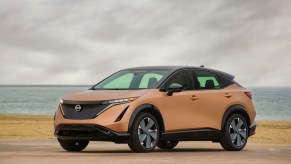 A gold 2023 Nissan Ariya parked outdoors.