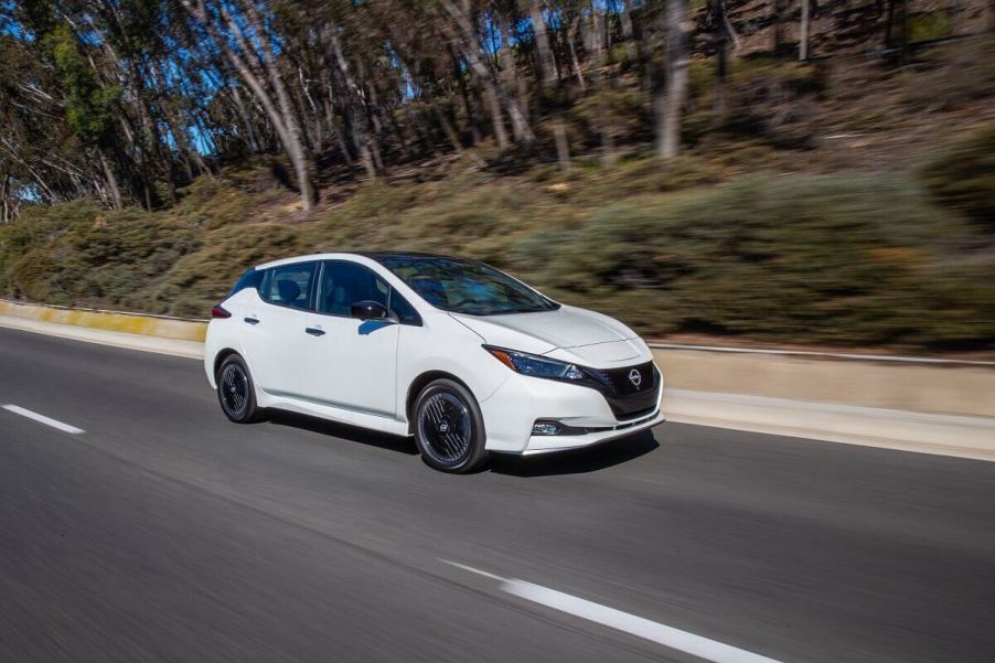 A white 2023 Nissan LEAF shows off its simple aesthetic as it cruises back roads.