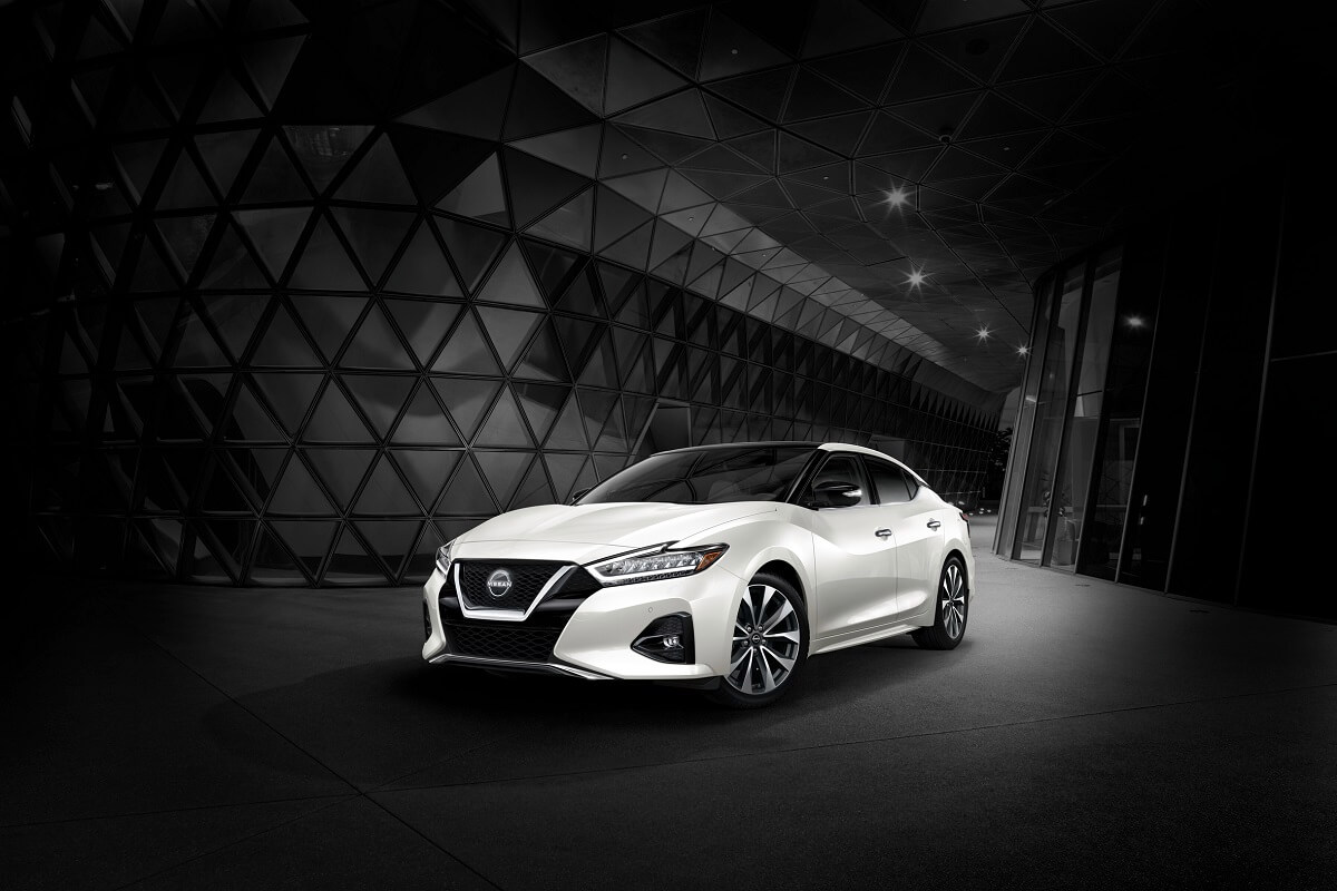 A white Nissan Maxima poses against a dark background.