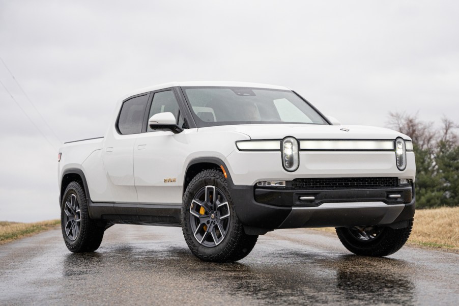 A white Rivian R1T parked on a road.