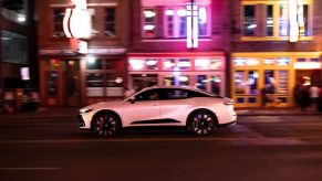 A 2023 Toyota Crown Platinum trim driving down a street at night.