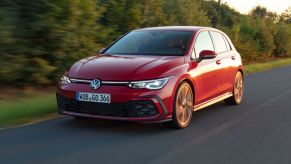 A red Volkswagen GTI drives in the desert