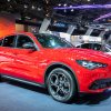 A red Alfa Romeo Stelvio parked indoors.