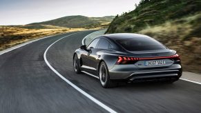 A gray Audi e-tron GT blasts down a country road.