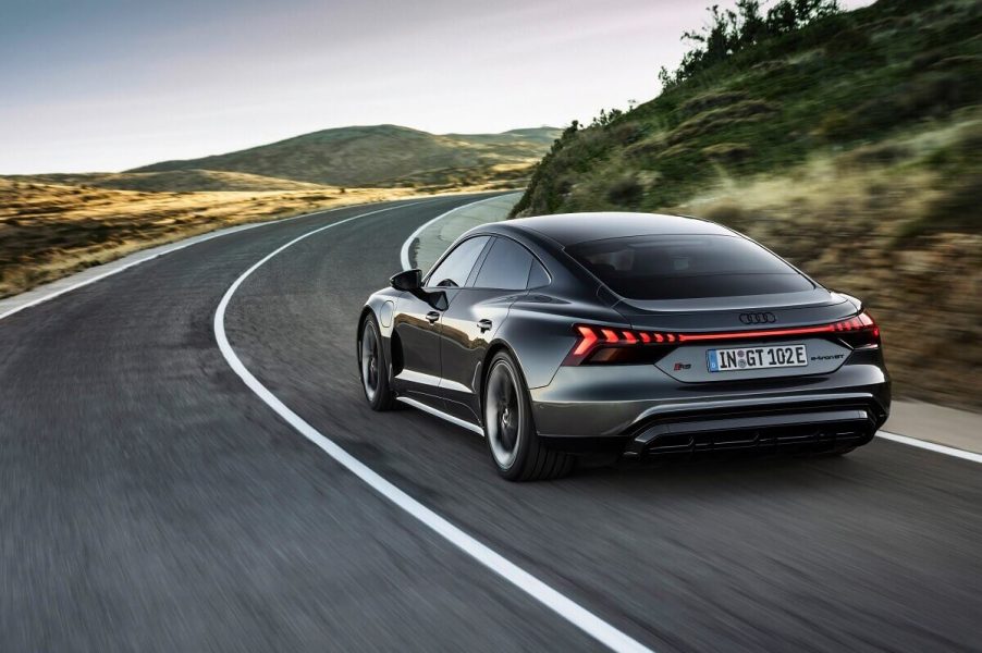 A gray Audi e-tron GT blasts down a country road.