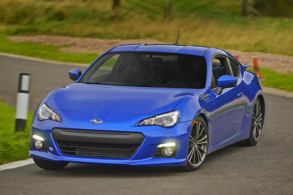 A blue Subaru BRZ sports car driving on a track.