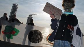 A Serbian boy holds a cardboard with the word "Benzene' written on it. This is one of the chemicals that makes gasoline smell good to us.