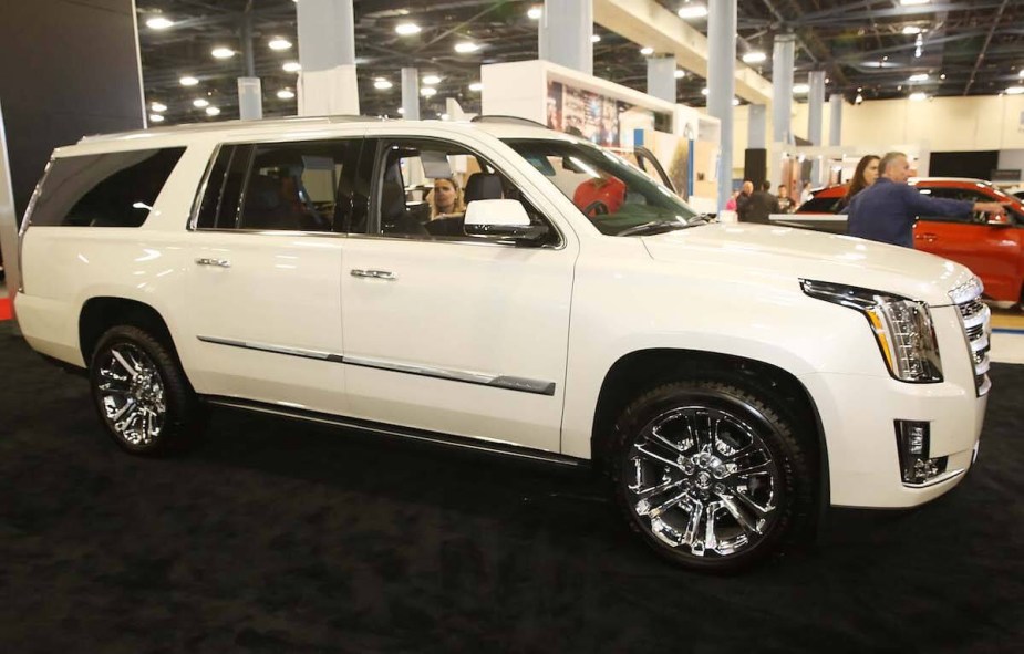 A white Cadillac Escalade parked indoors. 