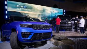 A blue Jeep Grand Cherokee 4xe on display at an auto show