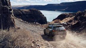 A 2023 Mazda CX-50 driving down a gravel road.