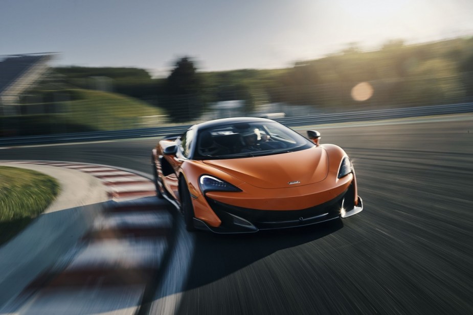 A McLaren 600LT screams around a test track in bright orange. 