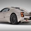 A side-rear profile promotional shot of a beige/tan Pagani Utopia hypercar model