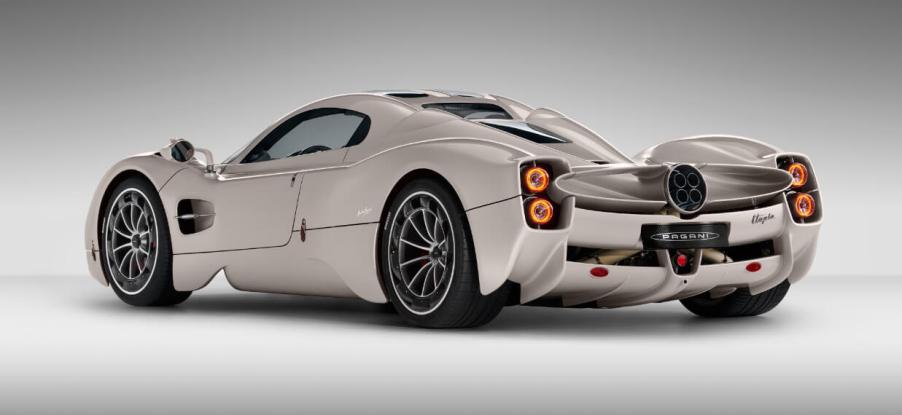 A side-rear profile promotional shot of a beige/tan Pagani Utopia hypercar model