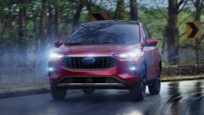 A red Ford Escape SUV driving down a road.