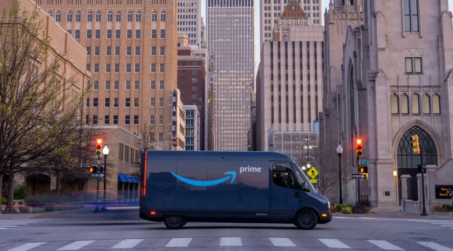 A Rivian Amazon delivery van shows off its unique design in a city.