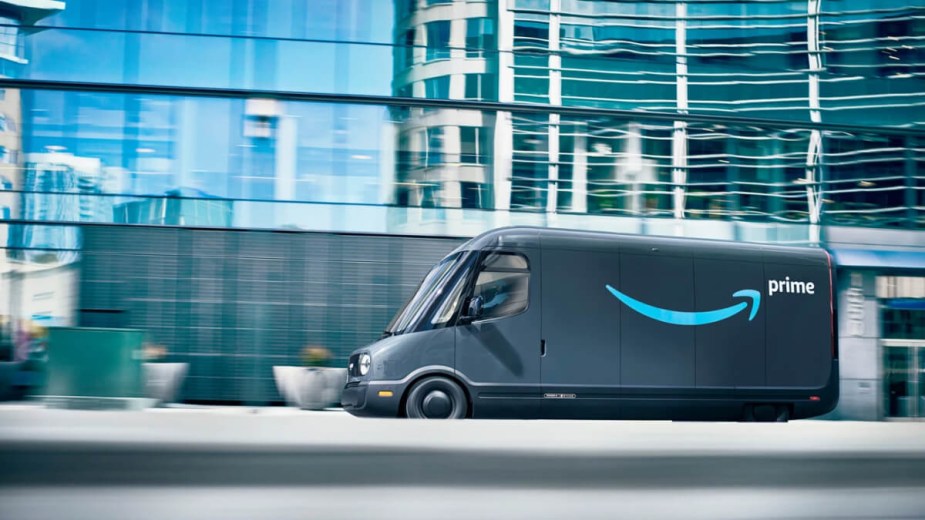 The Rivian Amazon van drives in a city.