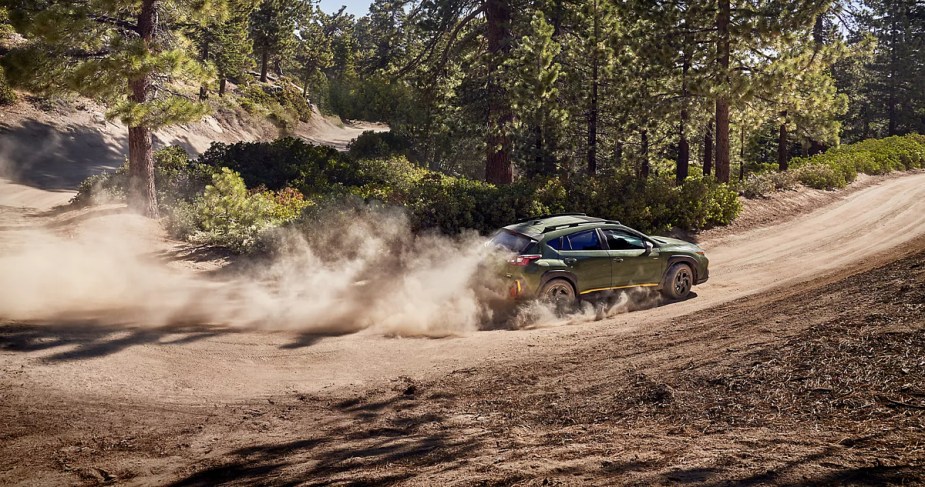 A 2024 Subaru Crosstrek drives on a dusty trail as a small SUV.