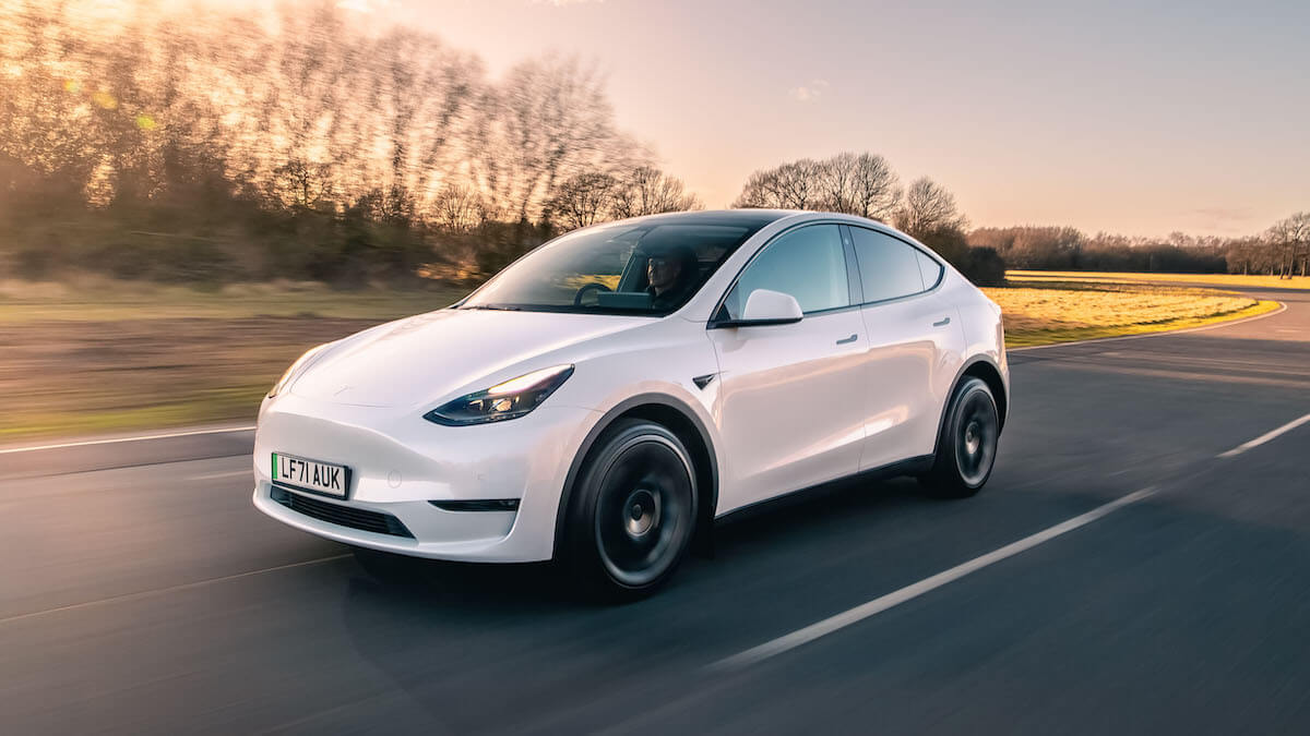 A 2023 Tesla Model Y driving down an open road.