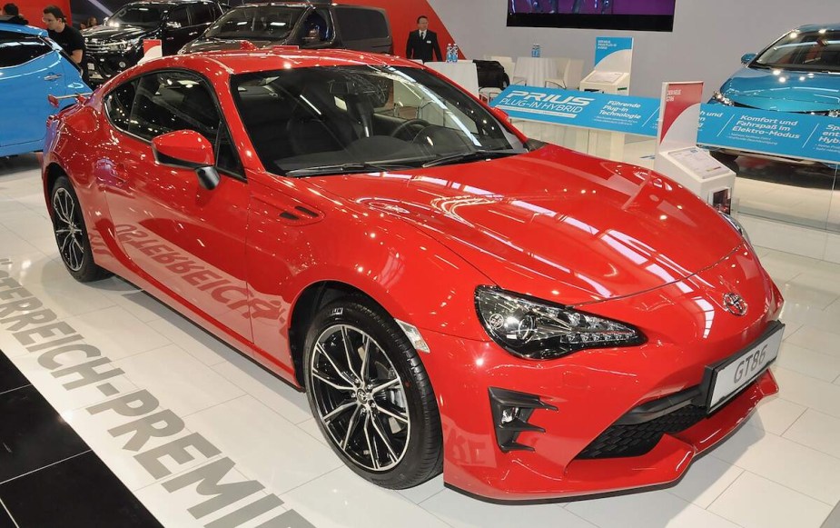 A red Toyota GR86 parked indoors. 