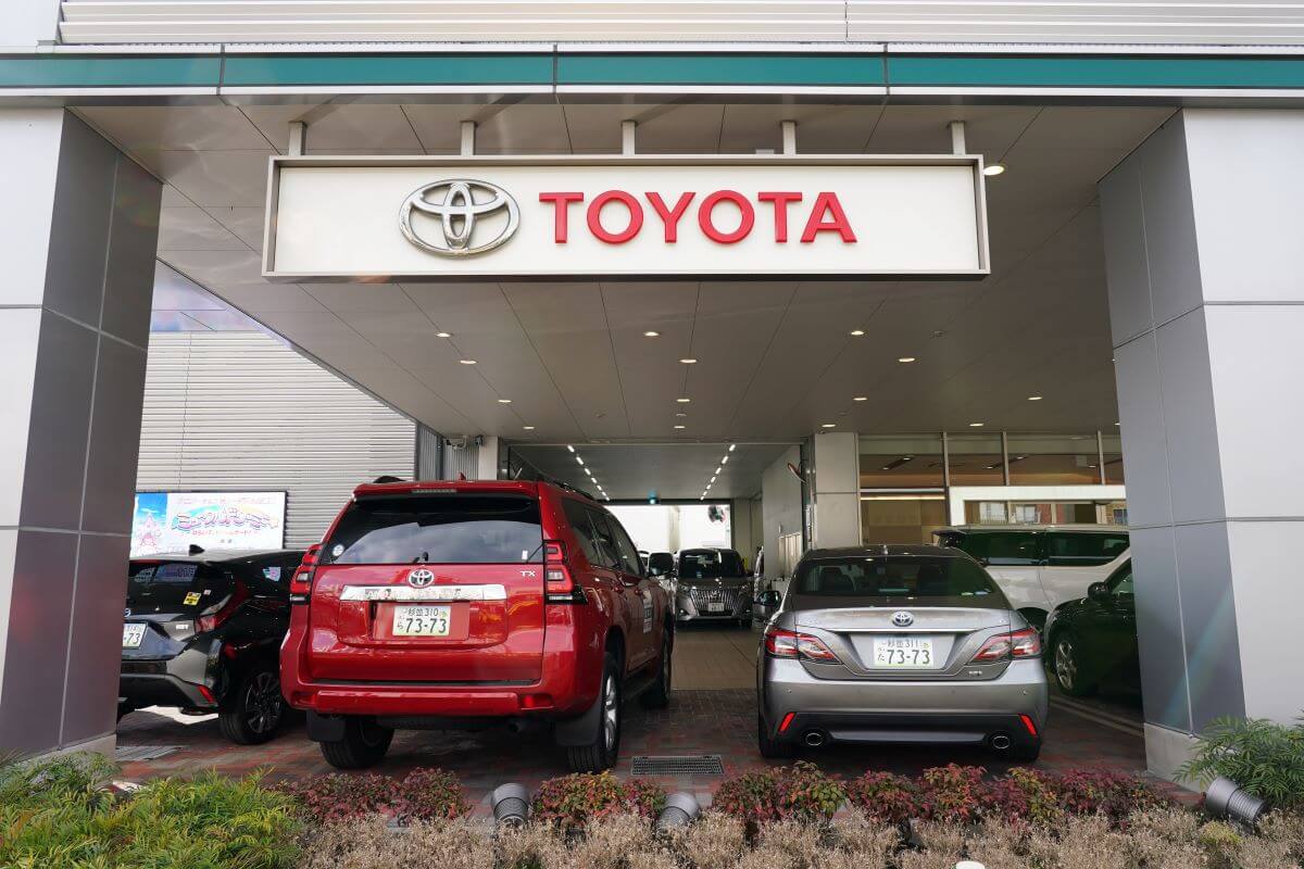 A Toyota Land Cruiser SUV and Crown sedan on display at a dealership in Tokyo, Japan