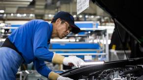 A Toyota factory worker inspects a vehicle to ensure the company's legendary reliability.