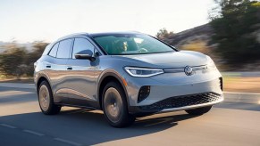 A gray 2023 Volkswagen ID.4 small electric SUV is driving on the road.