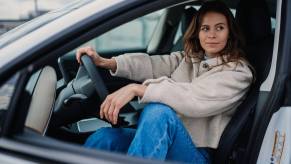 A woman driver sitting in the front seat of her Tesla car.