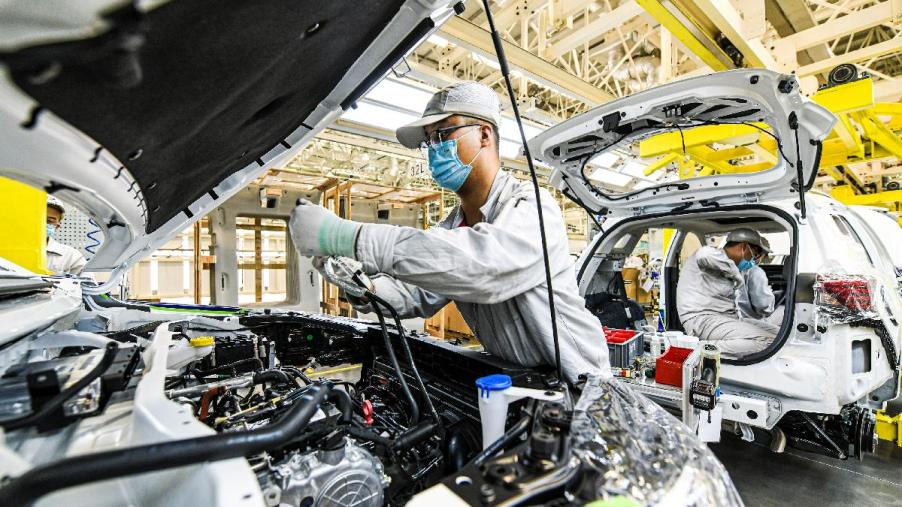 Workers at factory in Xinjiang, highlighting how car parts are from slave labor in China, per New York Times