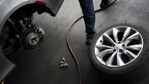 A mechanic works on a car's axle