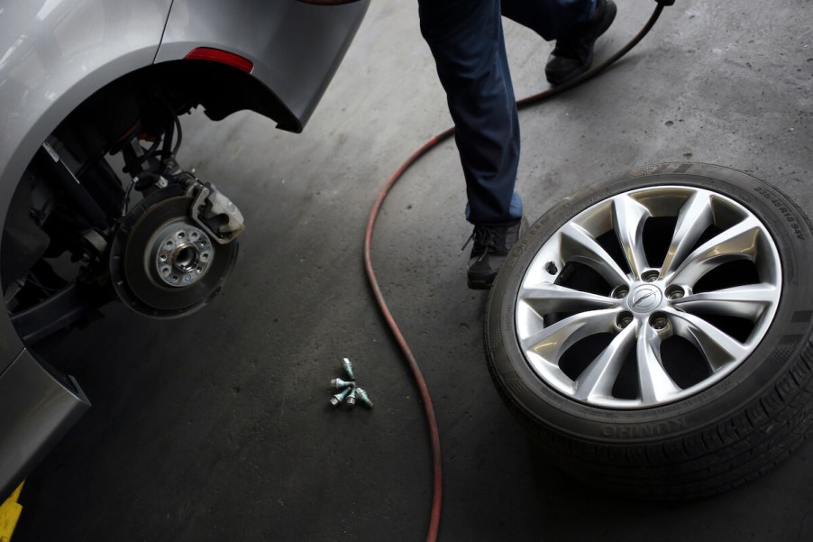 A mechanic works on a car's axle