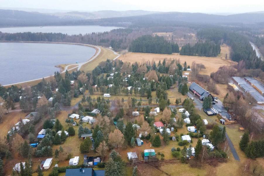 An aerial drone shot of motorhomes, RVs, and campers at the Galgenteich campsite in Altenberg, Saxony, Germany